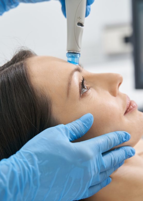 Woman having hydrafacial skincare procedure in cosmetology clinic